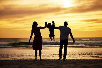 Image showing Beach silhouette, family holding child and sunset ocean holiday by waves, sand and summer sun background. Scenic travel vacation, relax by sea and swinging child together with love, care and freedom