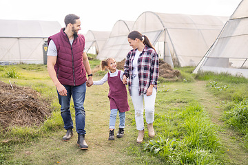 Image showing Farming, family and sustainable lifestyle with child and parents walking together on a field for love, bonding and support in countryside. Happy girl, man and woman on an agro and agriculture farm