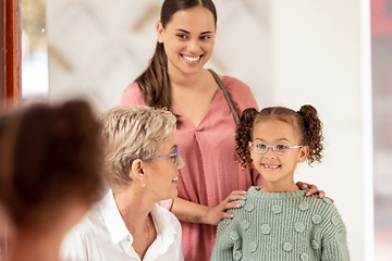 Image showing Mirror, vision and girl trying on glasses in an optical store with her mother and senior optometrist. Happy, smile and child choosing a eyewear frame for her prescription lens in a optics clinic.