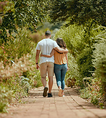 Image showing Hug, walk and couple on a path in nature for peace, relax and bonding together in summer. Back of a man and woman with affection, hugging and walking with love in a park or garden during spring