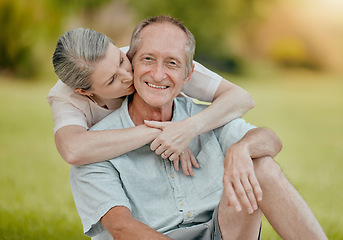 Image showing Senior couple, park and kiss for love, affection and care outside in a garden in summer. Mature, retired husband and wife bonding and being loving, caring and affectionate in romantic relationship
