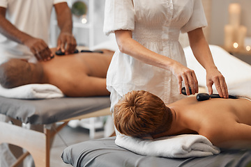 Image showing Hot stone massage, black couple and relax spa in skincare wellness, healthcare or stress management in hotel salon or resort. Woman, man and massage therapist with luxury rock therapy on love retreat