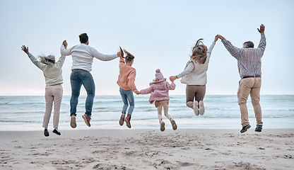 Image showing Family at the beach, adventure and jump, generations love and care while holding hands and fun by the ocean. Big family travel, parents with grandparents and children together and freedom at sea.