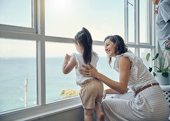 Image showing Family view, window and mother with child bonding, having fun and enjoy quality time together in home living room. Mamas love, happiness and mom with kid girl watch the ocean through glass window