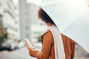 Image showing Umbrella, phone and woman in a street during rain, winter and morning in the city while texting, waiting and checking message. Commute, business woman waiting for taxi in rainy weather in New York