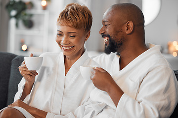 Image showing Coffee, love and mature couple on a sofa, happy and laughing while drinking coffee and relax in bathrobe in living room. Black family, tea and senior man and woman enjoy morning conversation on couch