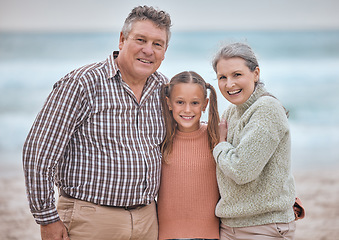Image showing Happy family, portrait and girl at the beach with grandparents relax, bond and smile, hug and love. Happy, seniors and child enjoy family time in nature, seaside and ocean fun on vacation together