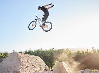 Image showing Bike, man and extreme jump at park, safety gear and outdoor for rush, competition and training for stunt. Bicycle, male athlete or dirt bike practice for fitness, contest or motivation for tournament