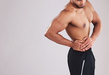 Image showing Fitness, sports and man with waist pain, topless in studio background. Sport injury, hurt muscle and a male model with muscular body in studio holding his side, health and body care at gym workout.