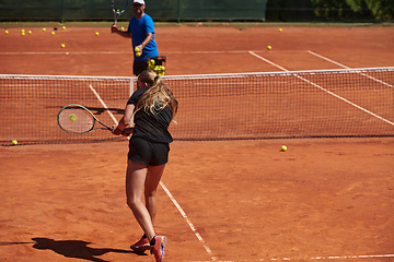 Image showing A professional tennis player and her coach training on a sunny day at the tennis court. Training and preparation of a professional tennis player