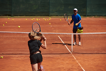 Image showing A professional tennis player and her coach training on a sunny day at the tennis court. Training and preparation of a professional tennis player