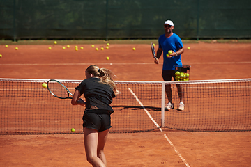 Image showing A professional tennis player and her coach training on a sunny day at the tennis court. Training and preparation of a professional tennis player