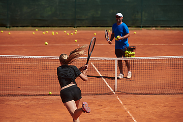 Image showing A professional tennis player and her coach training on a sunny day at the tennis court. Training and preparation of a professional tennis player