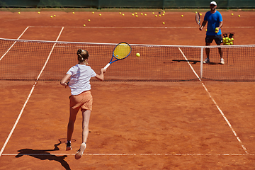 Image showing A professional tennis player and her coach training on a sunny day at the tennis court. Training and preparation of a professional tennis player