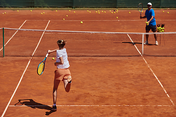 Image showing A professional tennis player and her coach training on a sunny day at the tennis court. Training and preparation of a professional tennis player