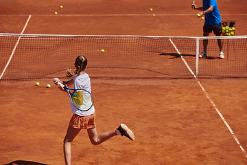 Image showing A professional tennis player and her coach training on a sunny day at the tennis court. Training and preparation of a professional tennis player