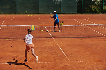 Image showing A professional tennis player and her coach training on a sunny day at the tennis court. Training and preparation of a professional tennis player