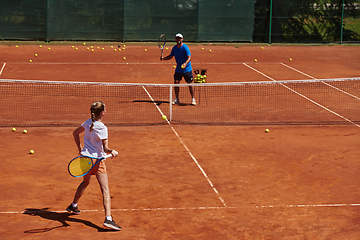 Image showing A professional tennis player and her coach training on a sunny day at the tennis court. Training and preparation of a professional tennis player