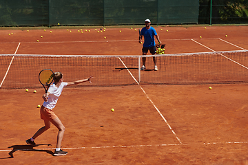 Image showing A professional tennis player and her coach training on a sunny day at the tennis court. Training and preparation of a professional tennis player