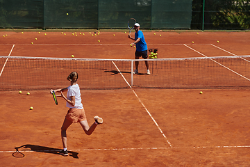 Image showing A professional tennis player and her coach training on a sunny day at the tennis court. Training and preparation of a professional tennis player