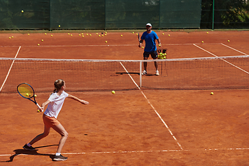 Image showing A professional tennis player and her coach training on a sunny day at the tennis court. Training and preparation of a professional tennis player