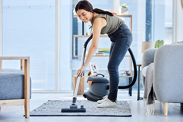 Image showing Smile, vacuum machine and woman cleaning the floor in the living room in home. Happy latino cleaner doing housework, housekeeper or job in a clean lounge, hotel room or house while spring cleaning
