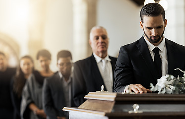 Image showing People, sad and funeral coffin, death and grief in church during ceremony or service, depression or floral. Support, emotional pain and sorry with casket, mourning and man in suit at casket in chapel