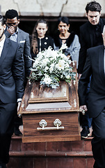 Image showing Death, funeral and people with coffin to cemetery, graveyard and morgue for burying, cremation or ritual. RIP, mourning and burial of dead in casket at church ceremony, respect and christian religion