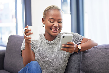 Image showing Woman, phone and relax on sofa with coffee for morning routine scroll social media. Happy African girl, streaming on smartphone and read digital 5g communication on couch with tea in living room