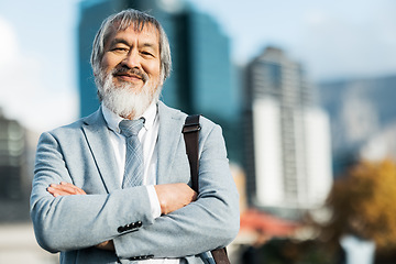 Image showing Mature asian businessman, portrait and proud man in the city during a commute or journey to work. City background, executive businessperson and arms crossed while leading on an urban background