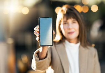 Image showing Woman, hand and phone mockup on bokeh background for mobile advertising, marketing or sale in the outdoors. Hands of female showing wireless technology smartphone for communication on blue chromakey