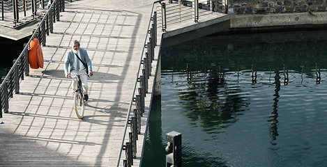 Image showing Businessman, asian and eco bike travel on bridge for carbon neutral work transportation in China. Worker, cycling and river commute with senior executive on outdoor sustainability trip with bicycle.