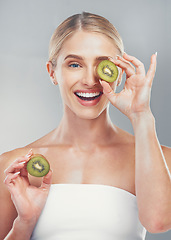 Image showing Happy studio portrait, woman with kiwi for skincare wellness, health and beauty by grey wall. Cosmetics model, girl with smile, fruit and self care for healthy facial, skin or vitamins by background