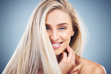 Image showing Hair care, smile and face of a woman with beauty, happy and natural makeup against a blue studio background. Skincare, wellness and portrait of a model with cosmetic body care and clean hair