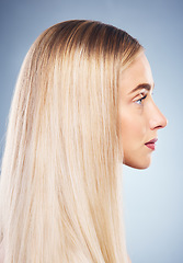 Image showing Woman, side and hair with beauty, blonde and studio closeup by blue background for hair care. Model, girl and young blonde with makeup, cosmetics or shine on locks for wellness by cosmetic backdrop