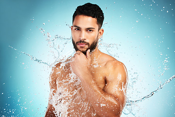 Image showing Portrait, water splash and skincare with shower, cleaning and wash in blue mockup studio background. Health, cleaning and pride of model washing with blue studio mockup for cosmetic marketing.