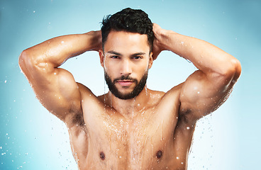 Image showing Health, shower and skincarre with man in studio for health, wellness and healthy lifestyle, body wet with water on blue background. Portrait of model in studio for self care and fitness motivation
