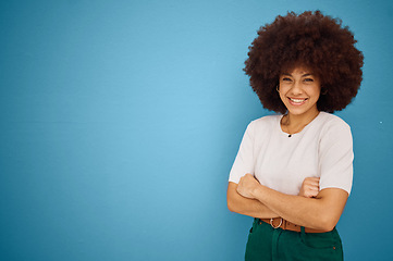 Image showing Black woman, arms crossed and natural hair or afro happiness by marketing, advertising or mockup space on blue studio background. Portrait of a happy model showing smile and promotion mock up