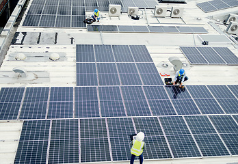 Image showing Grid, solar energy and roof construction engineering people working on renewable energy installation. Sustainability, solar panel and professional contractor team work on building rooftop.