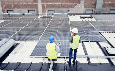 Image showing Engineer, planning and solar panel installation, maintenance and teamwork for renewable energy on a roof outdoor. Collaboration, planning and construction workers talking about clean or solar energy