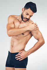 Image showing Shoulder pain, injury and fitness man in underwear in mockup studio background. Inflammation, hurt muscle and a male model with muscular body in holding his arm, health and body care after workout