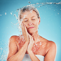 Image showing Senior woman, water and skincare for hydrate, hygiene and fresh clean treatment against a blue studio background. Happy elderly female touching face for smooth facial hydration or skin moisture