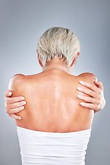 Image showing Skincare, back and senior woman with a hug for self love, beauty and care against a grey studio background. Wellness, natural and body of an elderly model hugging for empowerment and confidence