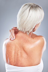 Image showing Ache, pain and woman with neck injury on a grey studio background for body accident. In pain, back inflammation and physical strain of a woman anatomy from behind on a grey background.