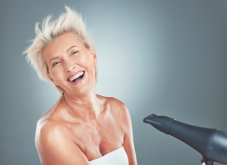 Image showing Hair care, happy and senior woman with a dryer for beauty, treatment and happiness against a grey mockup studio background. Cosmetic, smile and portrait of an elderly person with a hairdryer for hair