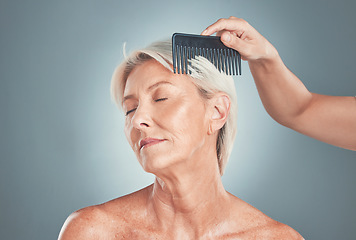 Image showing Senior woman, beauty and hand comb hair for cosmetic care or wellness treatment. Elderly person, closed eyes and arm brushing healthy short locks for natural healthcare in blue backgriund studio