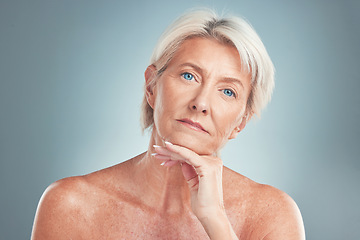 Image showing Senior woman, beauty and skincare with blue eyes posing for cosmetics against a grey studio background. Portrait of a confident isolated elderly female model in pose for anti aging facial treatment