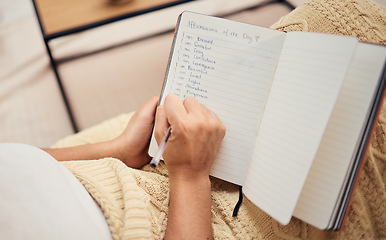 Image showing Book, hand and woman writing list in her notebook while relaxing with ideas and future vision. Self love, self care and female hands write motivational list in her journal for mental health