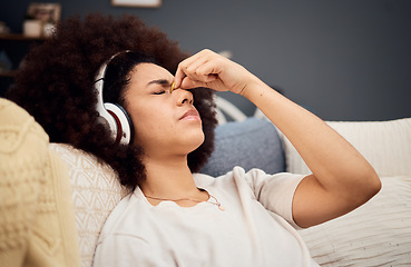 Image showing Headache, pain and woman with headphones of sofa tired, exhausted and trying to relax. Stress, fatigue and black woman listening to music at home streaming song, track and radio for stress relief