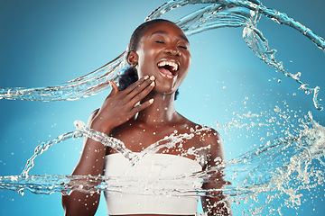 Image showing Water, splash and woman washing for hygiene and grooming on a blue studio background. Young black woman wash, cleanse and cleansing body and skin for bodycare, skincare and health or wellness